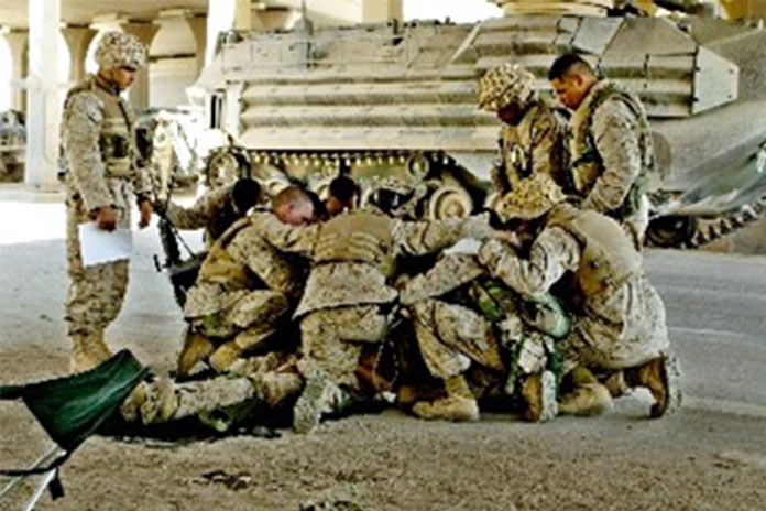 U.S. Marines pray over a fallen comrade after he died from wounds suffered in fighting in Fallujah, Iraq, April 8, 2004.AP Photo/Murad Sezer, File